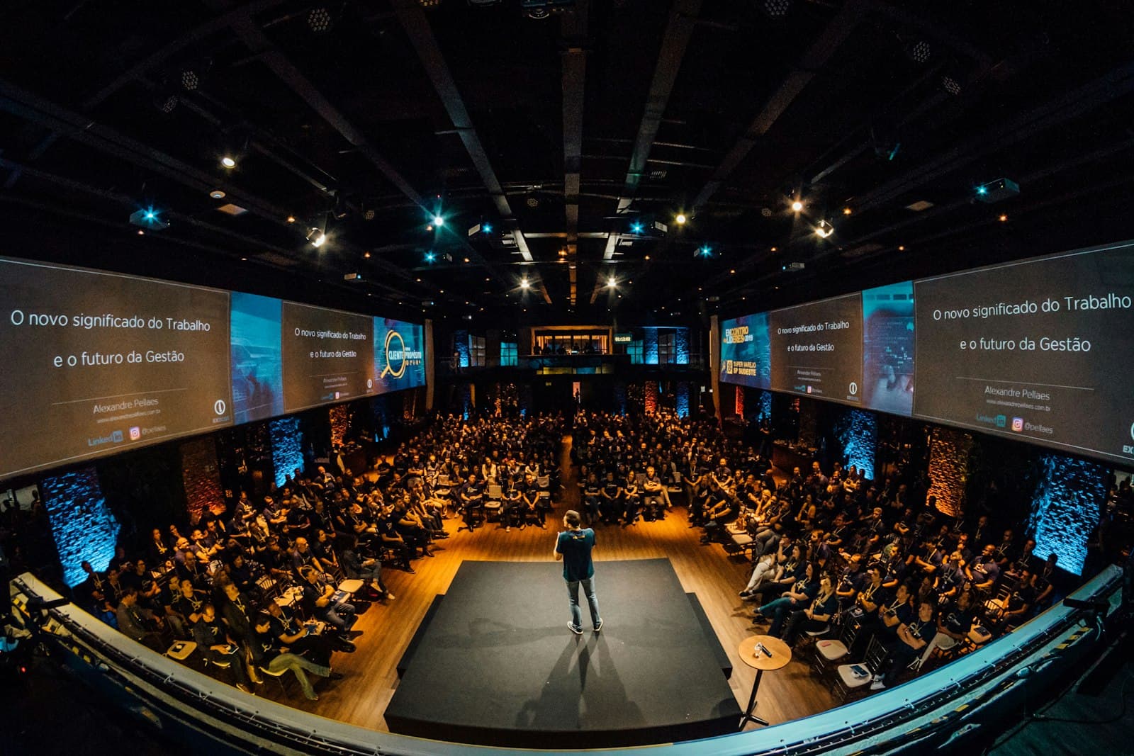 Een zaal vol mensen die luistert naar een spreker op een tech-community-event