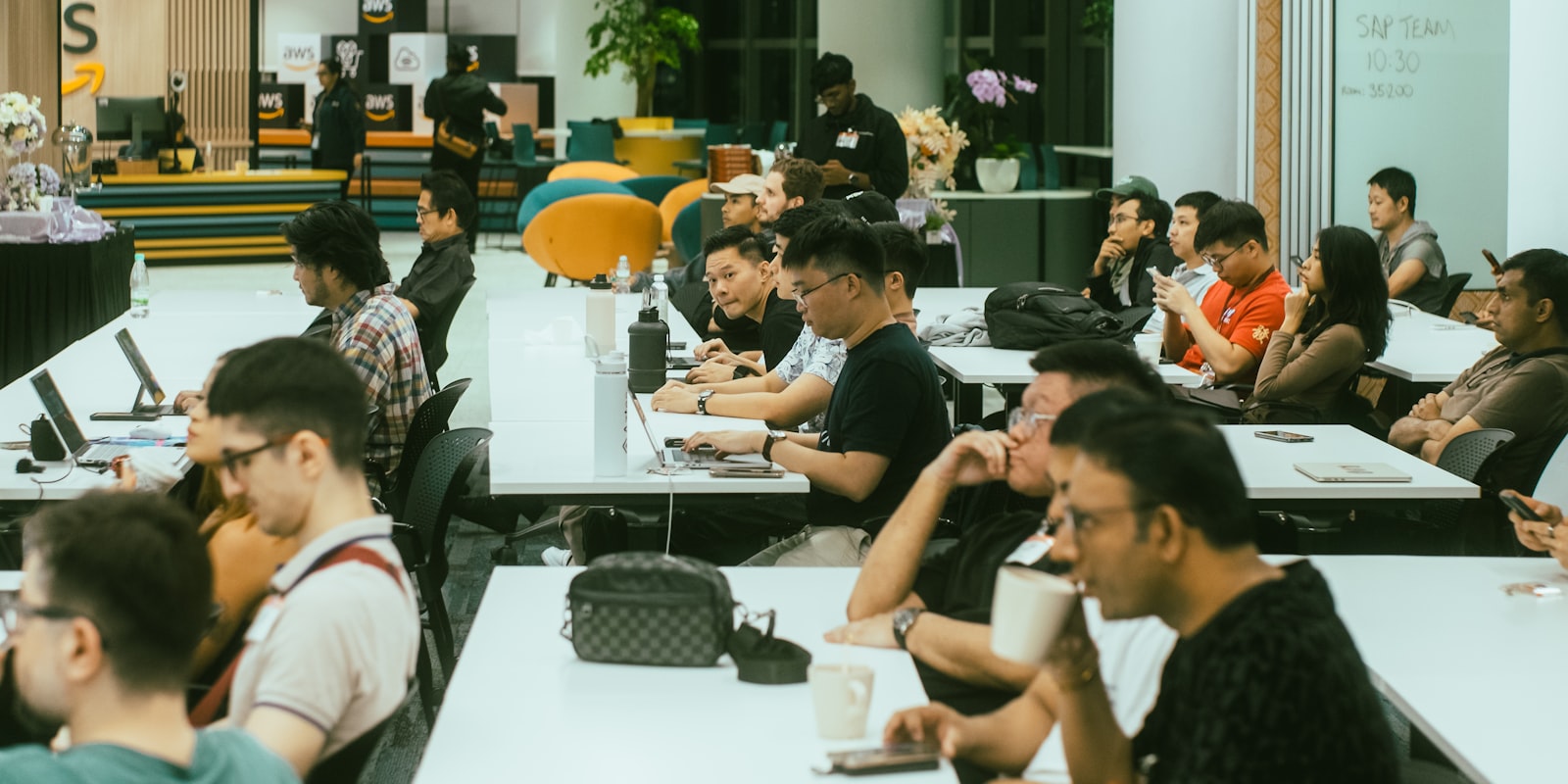 Twee AI-professionals achter laptops in een peer-learning-sessie binnen een community-ruimte